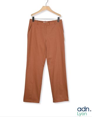 un gros plan sur le pantalon d'une personne suspendu à un cintre