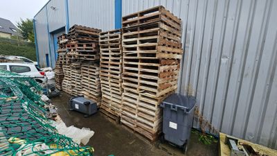 a lot of crates that are stacked on the side of a building