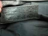 a person holding a black leather belt with a silver buckle