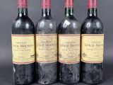 three bottles of red wine sitting next to each other on a table