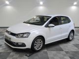 une Volkswagen Polo break blanche garée dans une pièce au sol carrelé