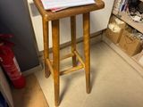 un petit tabouret en bois dans un coin de la pièce