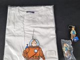 an image of a t - shirt with a picture of a man in a space suit on it and a keychain