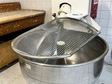 un grand saladier en métal posé par terre dans une cuisine