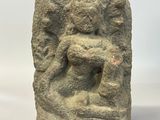 an ancient stone head on a wooden base with a white background