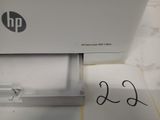 a hp printer sitting on top of a desk next to a piece of paper