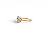 a close up of a ring with a pink and white diamond