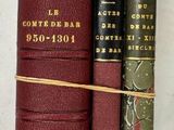 trois livres posés l'un à côté de l'autre sur une table