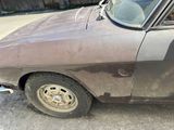 an old car that has been rusted and is parked in a lot