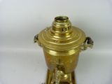 a gold colored coffee urn on a white surface