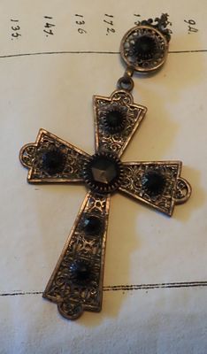 a cross that is sitting on a piece of paper