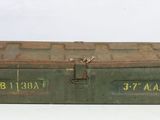 an old green metal box sitting on top of a white table