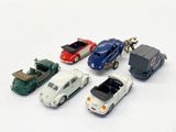 several toy cars are lined up in a row on a white surface