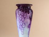 a purple vase sitting on a table with a white background