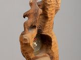a wooden sculpture of a bear and a bear cub on a rock