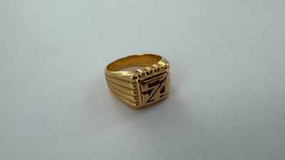 gros plan d'une bague en or sur une surface blanche