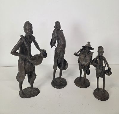 three bronze figurines of a man and a woman with baskets