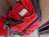 a red backpack sitting on the floor next to a door