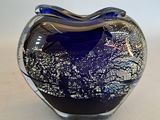 a blue glass heart shaped object on a table