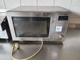 a microwave sitting on a counter with a cord attached to it