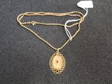 un gros plan d'un collier en or orné d'un médaillon
