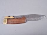 a knife with a wooden handle on a white surface