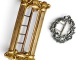 a gold brooch and a silver brooch on a white background
