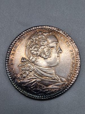 une pièce en argent portant le portrait d'un homme