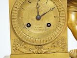 a gold clock with a statue of a woman on it