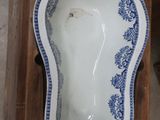 a blue and white bowl sitting on a wooden stand