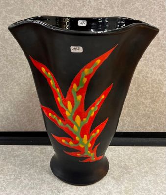 un vase noir orné d'une fleur rouge et jaune