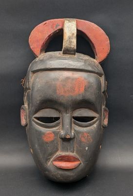 gros plan d'un masque en bois sur fond noir
