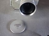 a silver camera sitting on a table next to a button