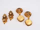 a pair of gold earrings and a broochle