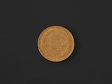 a close up of a gold coin on a black surface