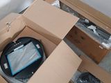 une boîte en carton contenant un ordinateur portable, posée par terre