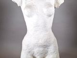 sculpture représentant un torse féminin sur un mannequin, sur fond gris