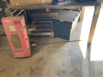 a red fire hydrant sitting in a garage next to a stack of boxes