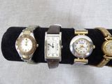 three watches are sitting on a black display case