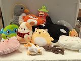 many stuffed animals sitting on a table in a room