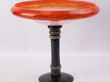 un socle orange et noir surmonté d'un bol en verre