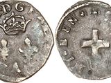 a silver coin with a cross on the front and a crown on the back