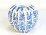 un vase bleu et blanc posé sur une surface blanche