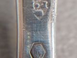 a close up of a silver spoon with a flower on it
