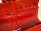 a red chanel purse with a chain hanging from it