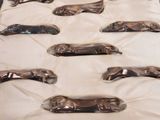 many silver spoons sitting on a white surface