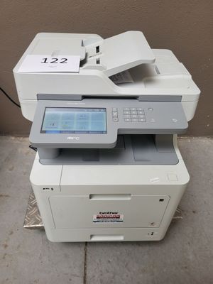 a white printer sitting on top of a table next to a brown wall