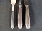 two spoons and a knife on a black table