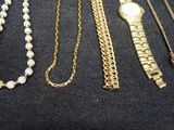 many different types of necklaces and bracelets laid out on a table