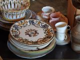 many plates and cups on a table with a vase